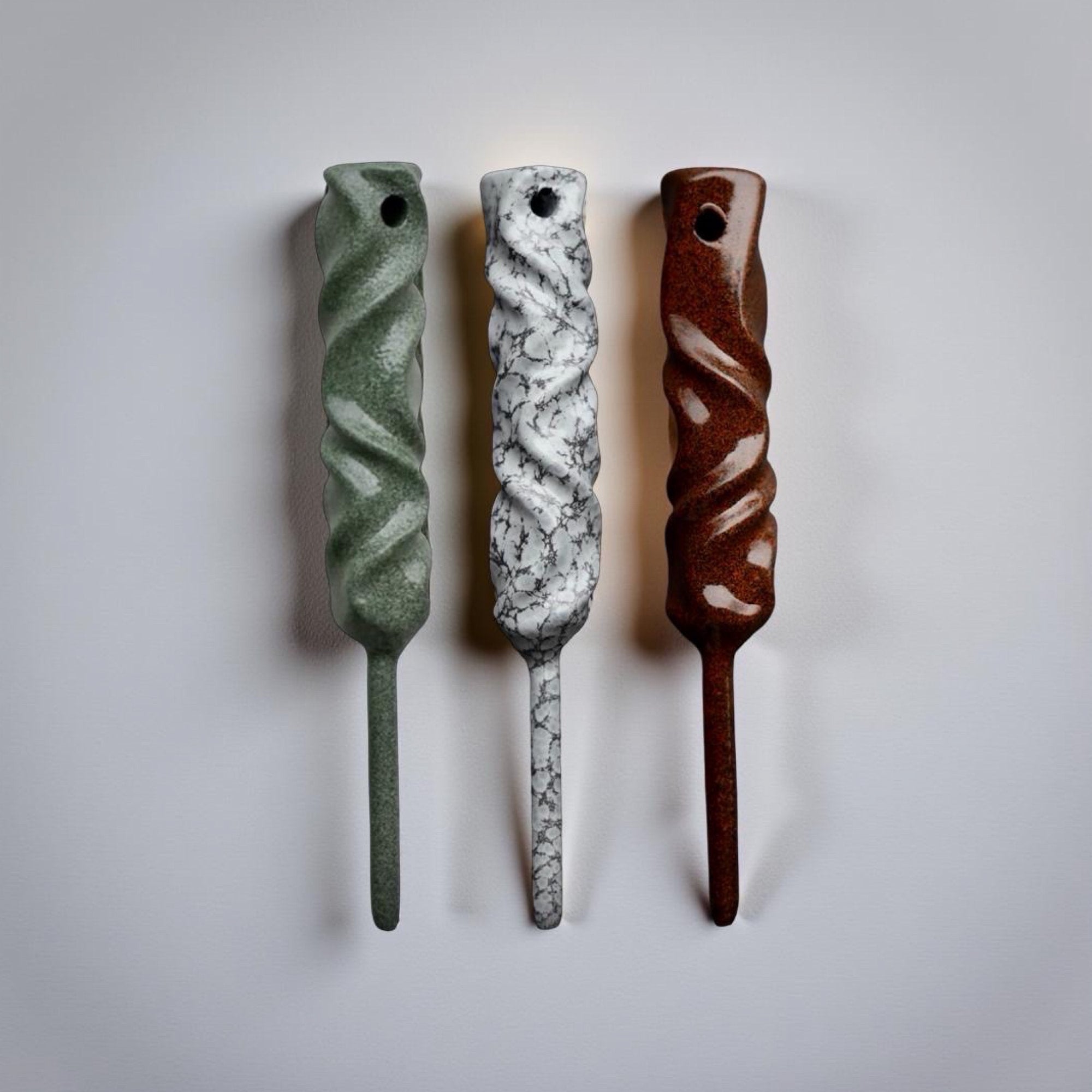 Handmade powder-coated golf divot tools from the Twisted Metal Collection shown in three finishes on a neutral background