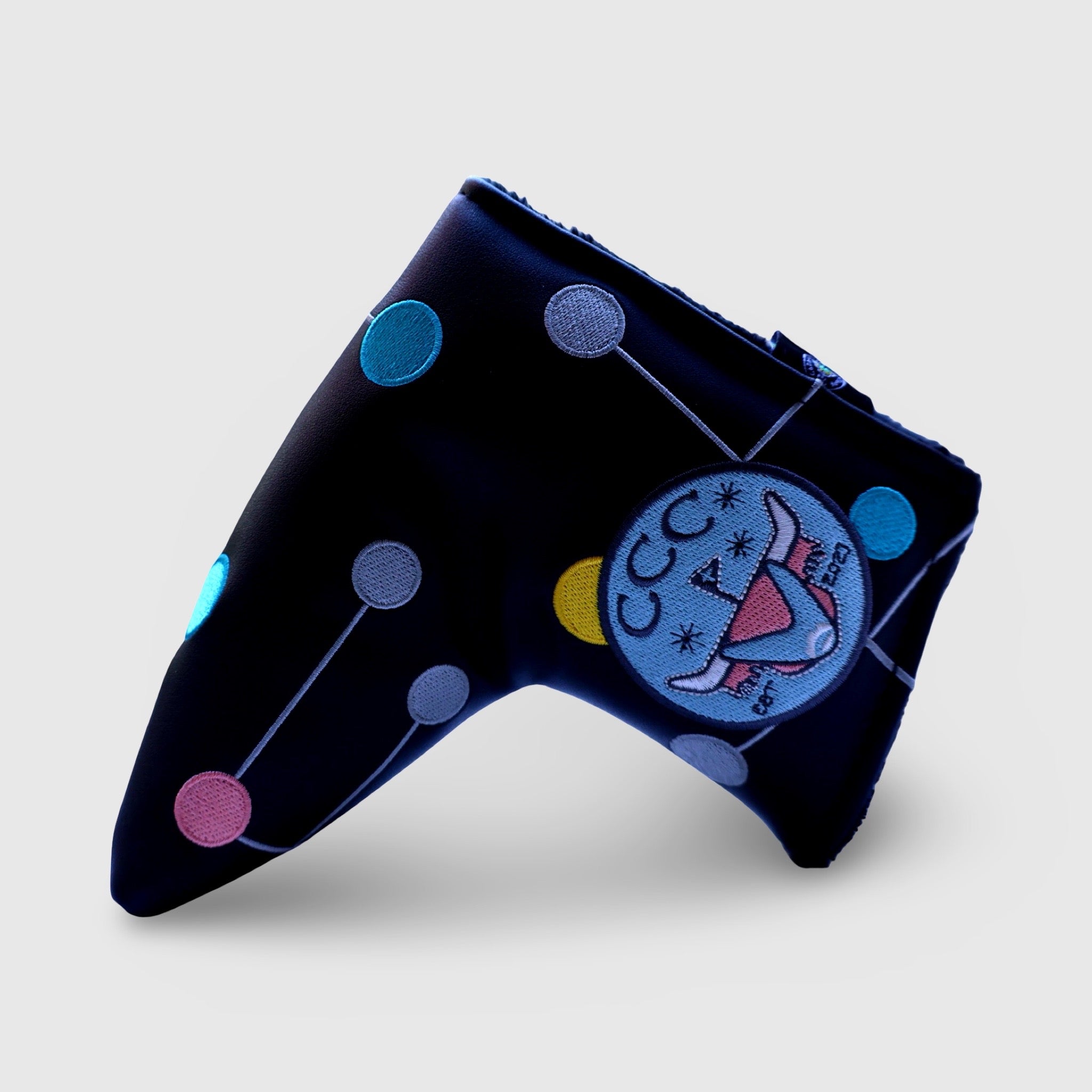 Side angle view of Atomic Era blade putter headcover highlighting embroidered pastel orbit pattern