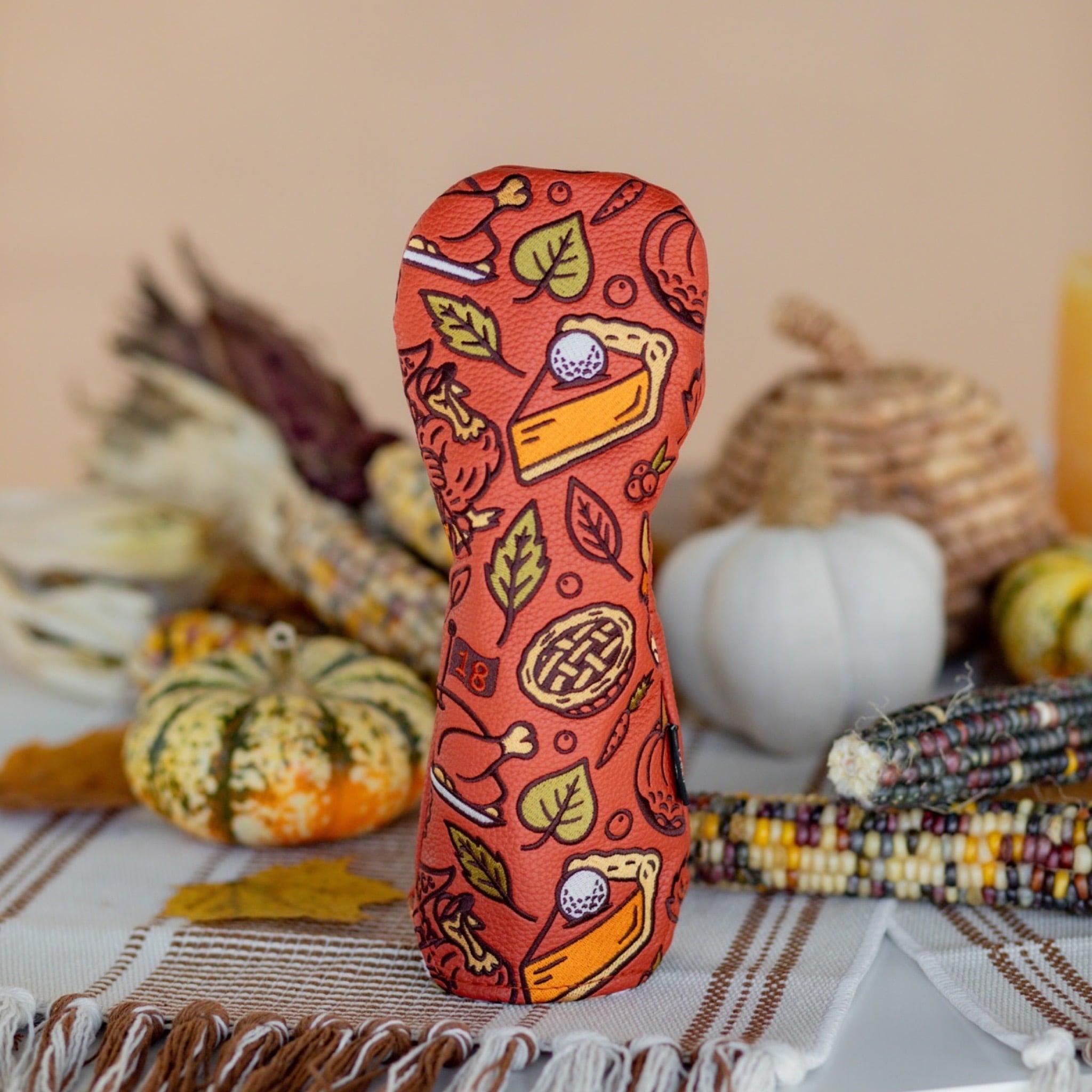 Autumn Feast hybrid headcover by Caddy Collective Culture displayed in a clean fall-themed setting with pumpkins and corn decor.