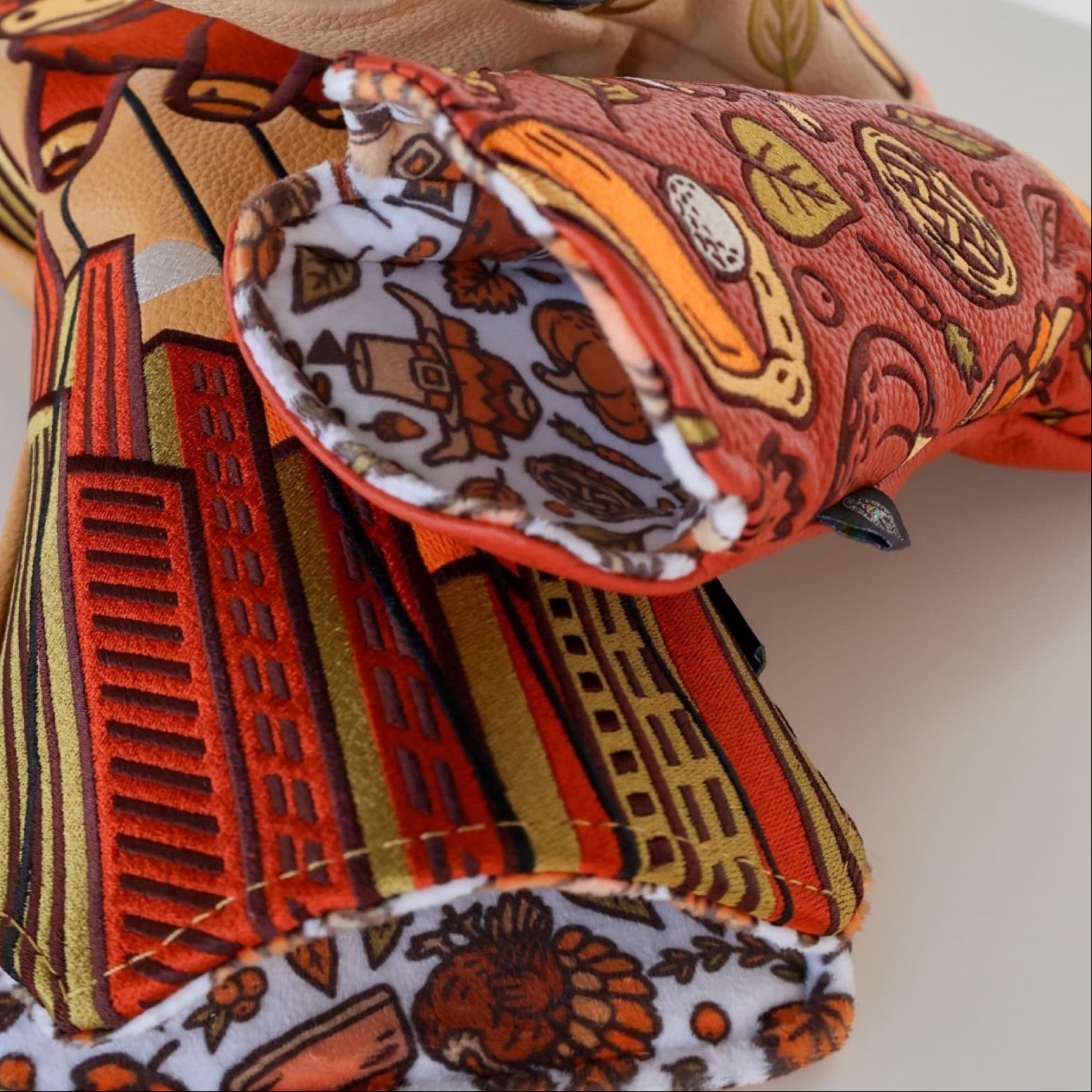 Detail shot of the Autumn Feast hybrid headcover showing the custom printed inner lining with Thanksgiving illustrations.