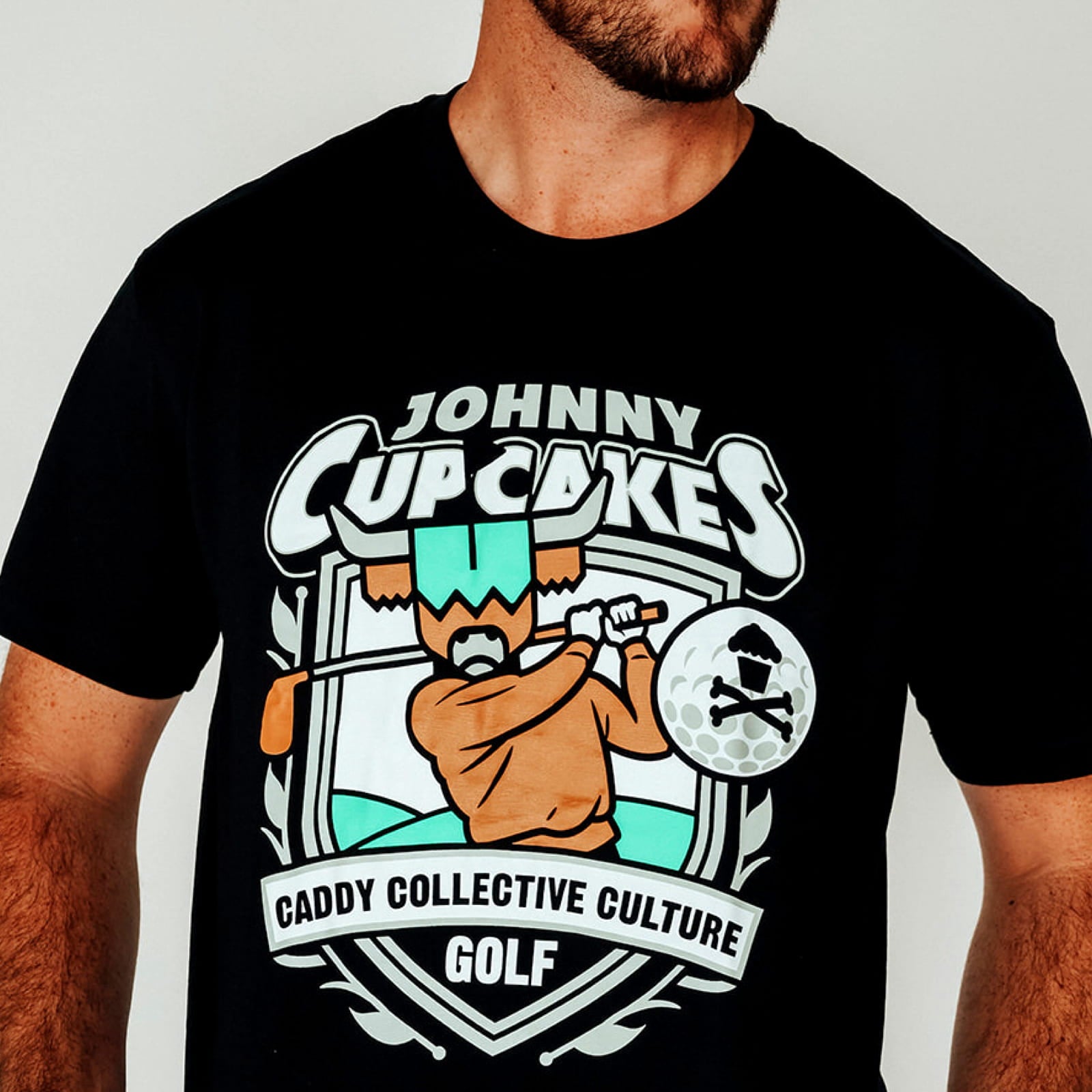 Model wearing Johnny Cupcakes x CCC golf T-shirt, golfer logo visible