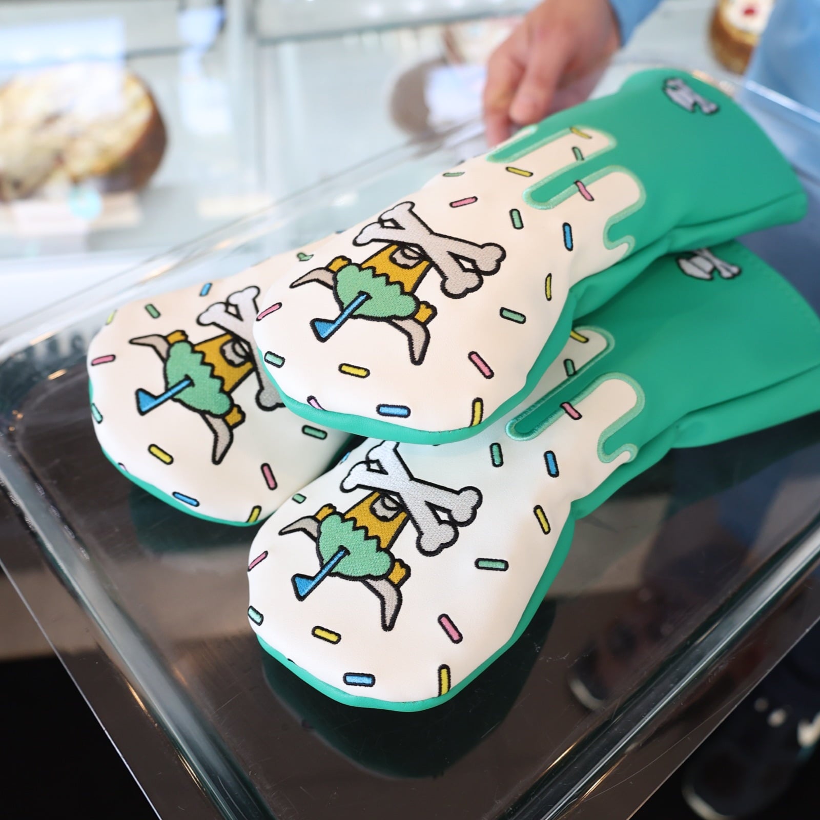 Johnny Cupcakes x Caddy Collective Culture golf hybrid headcovers with sprinkle cupcake design displayed on bakery tray.