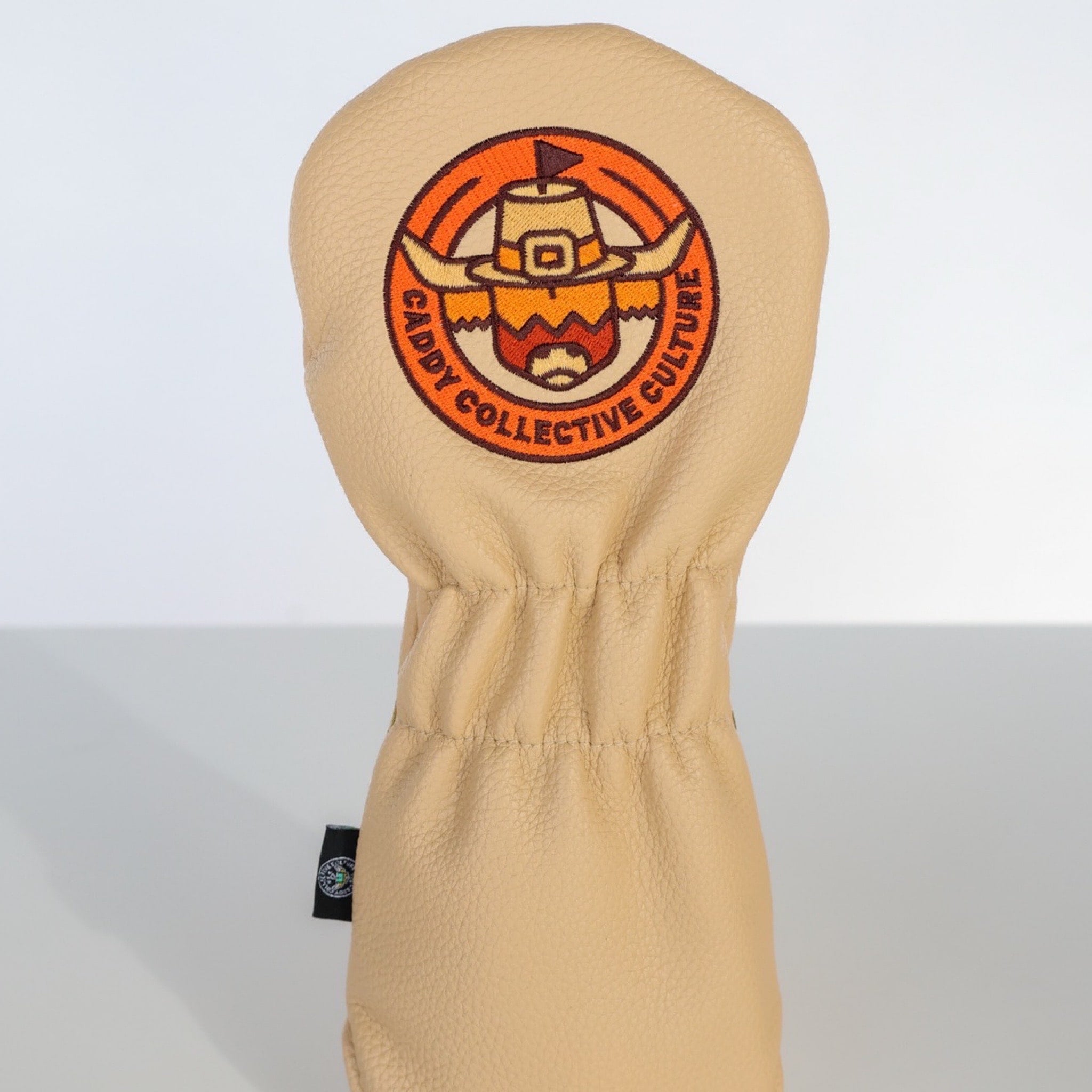 Back view of the Pilgrim Looper fairway headcover featuring the embroidered pilgrim Looper emblem on cream leather.