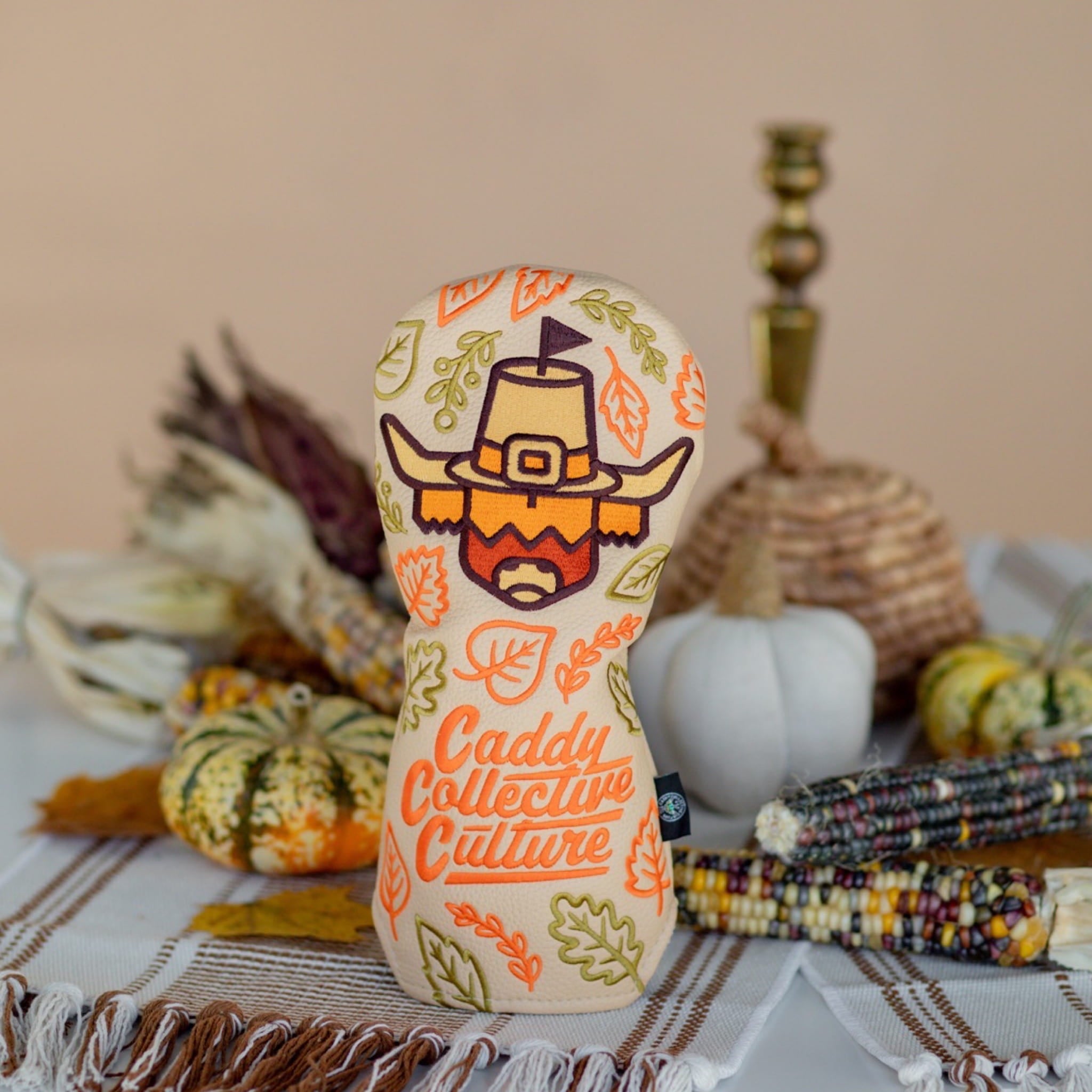 Pilgrim Looper fairway headcover standing upright in a fall-themed setting with pumpkins, corn, and Thanksgiving decor.