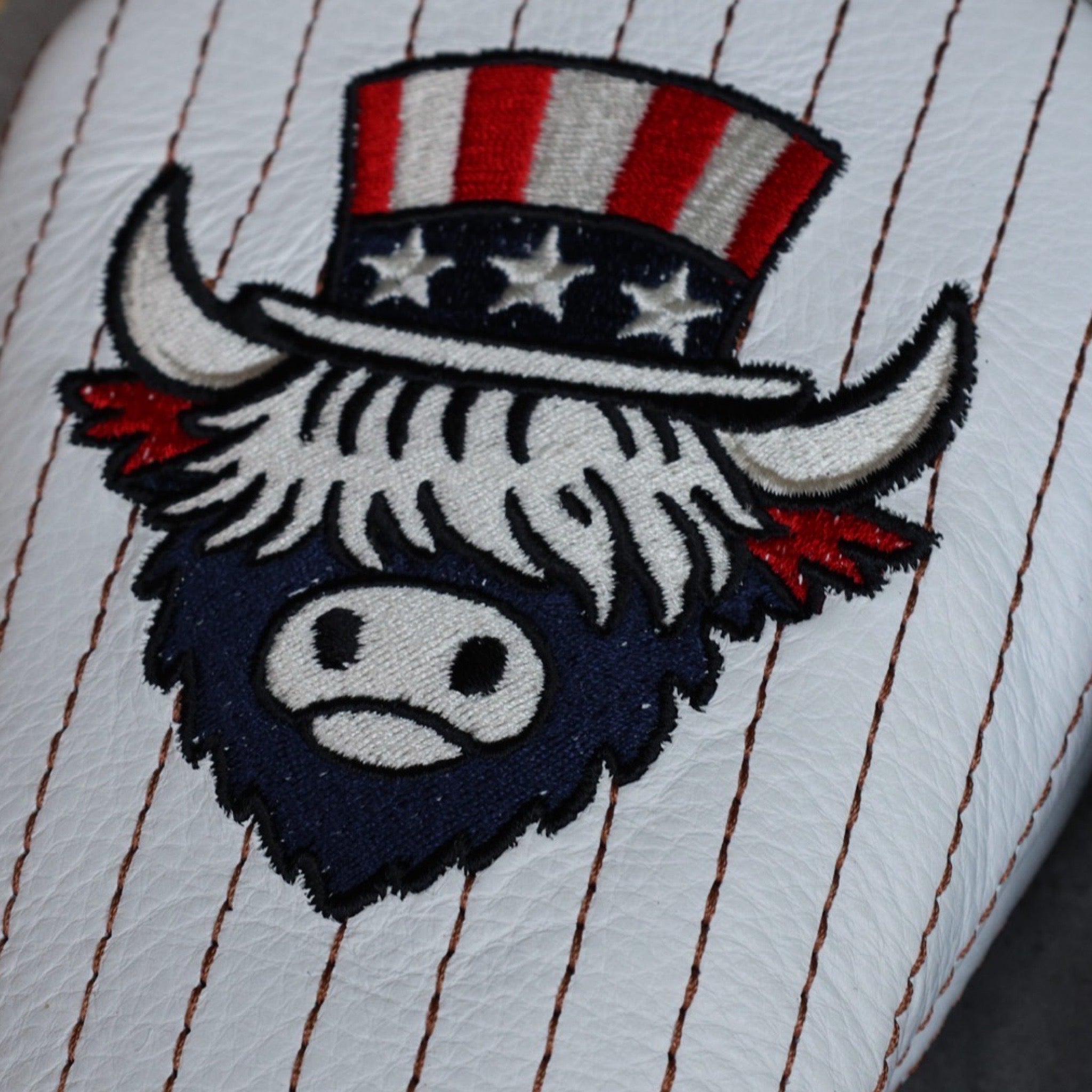 Detailed embroidery view of Uncle Sam Looper logo on The Founder Fairway Cover