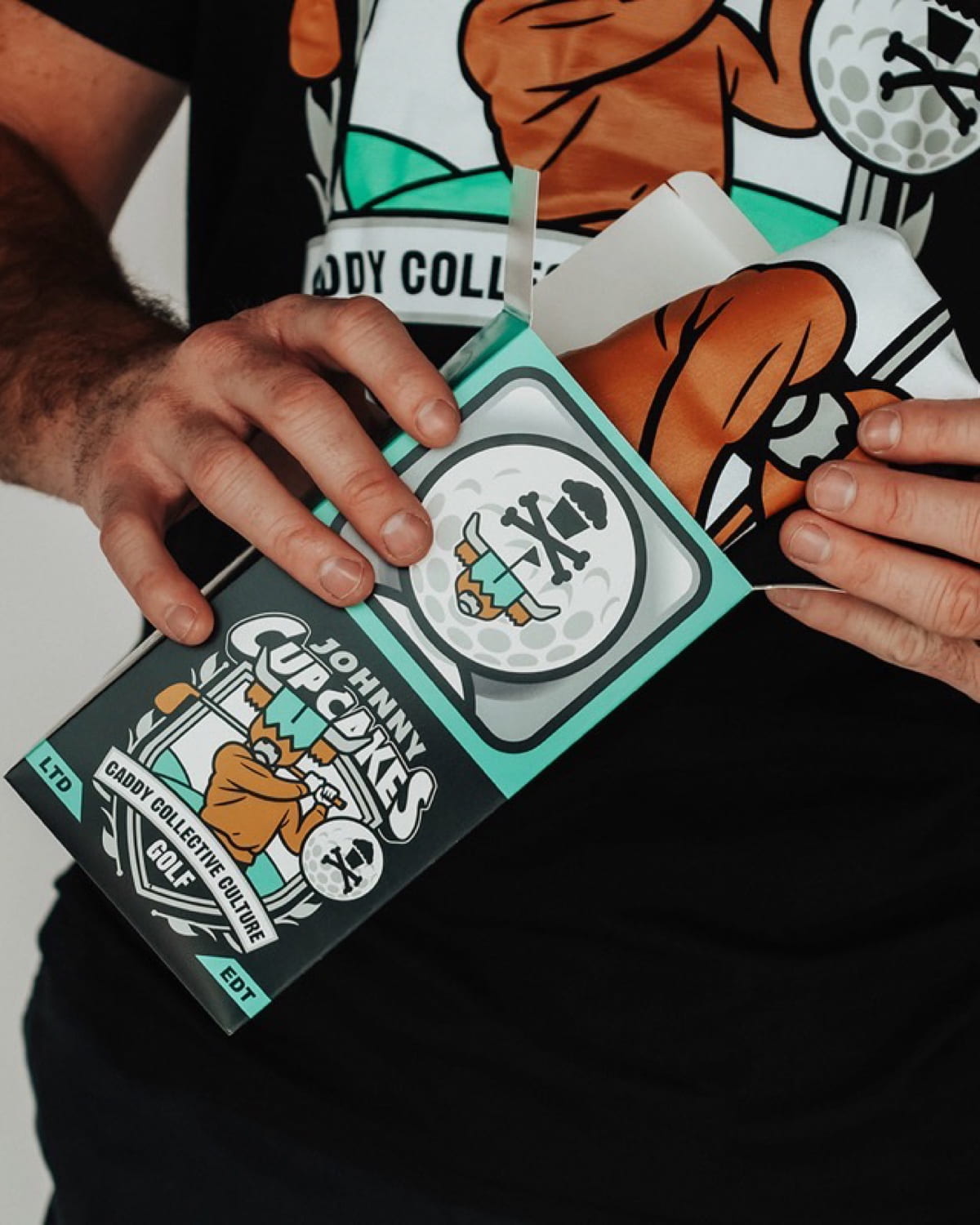 Johnny Cupcakes custom golf merchandise collaboration featuring limited-edition packaging designed by Caddy Collective Culture.