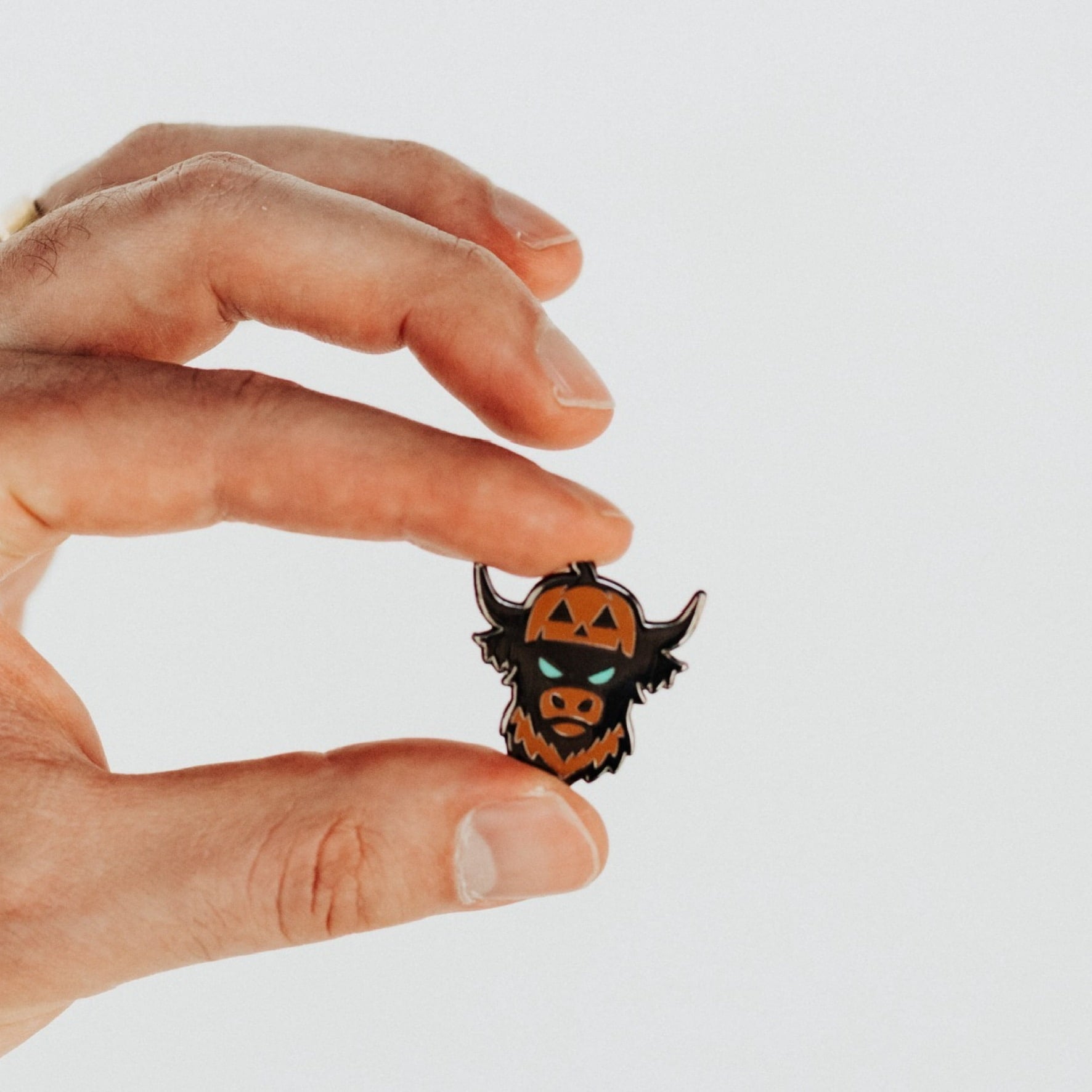 Looper After Dark ball marker held in hand front view with pumpkin Looper design