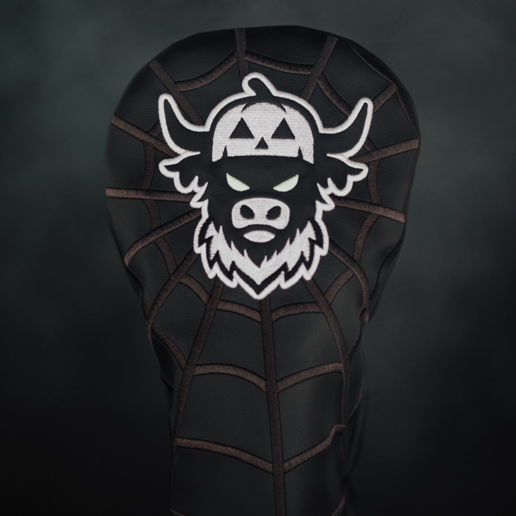 Close-up of Looper After Dark headcover showing spiderweb stitching texture and embroidered Looper design