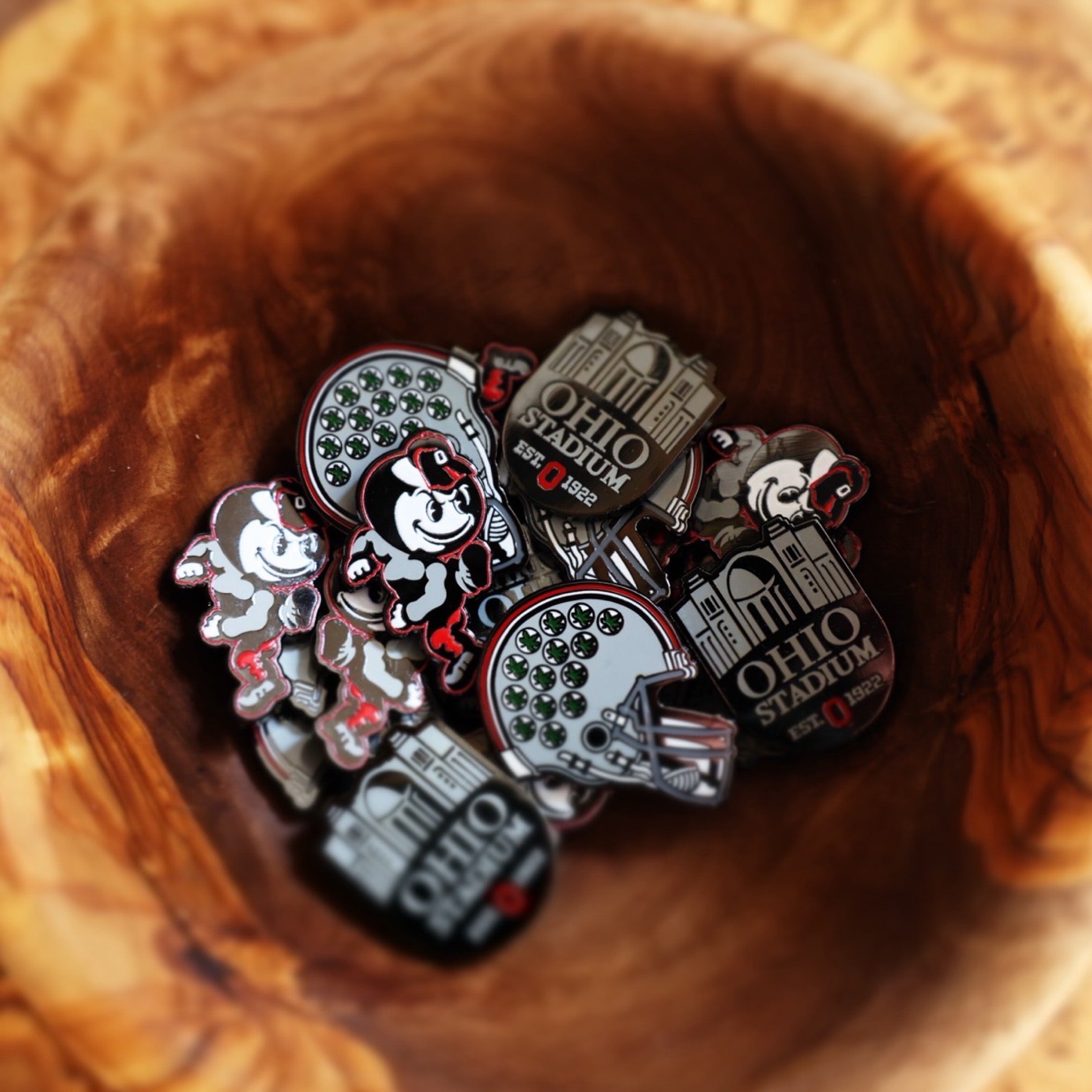 Ohio State Heritage Brutus Ball Marker featured inside carved wooden bowl with Buckeye Right Helmet and Horseshoe markers