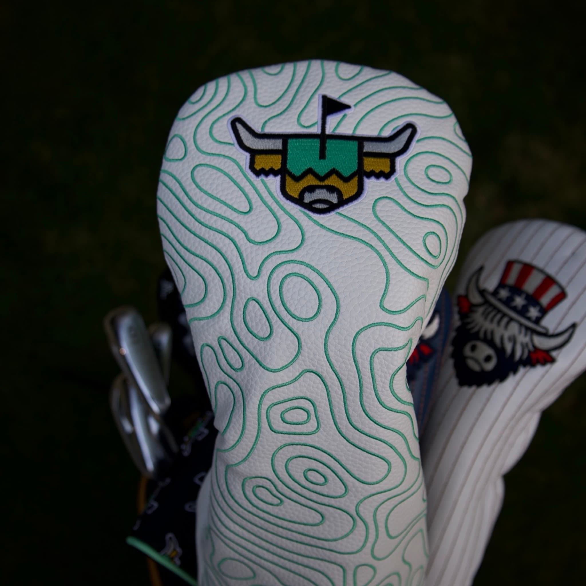 Terrain Driver Headcover on a golf bag showing the white pebbled grain leather and embroidered green contour pattern.