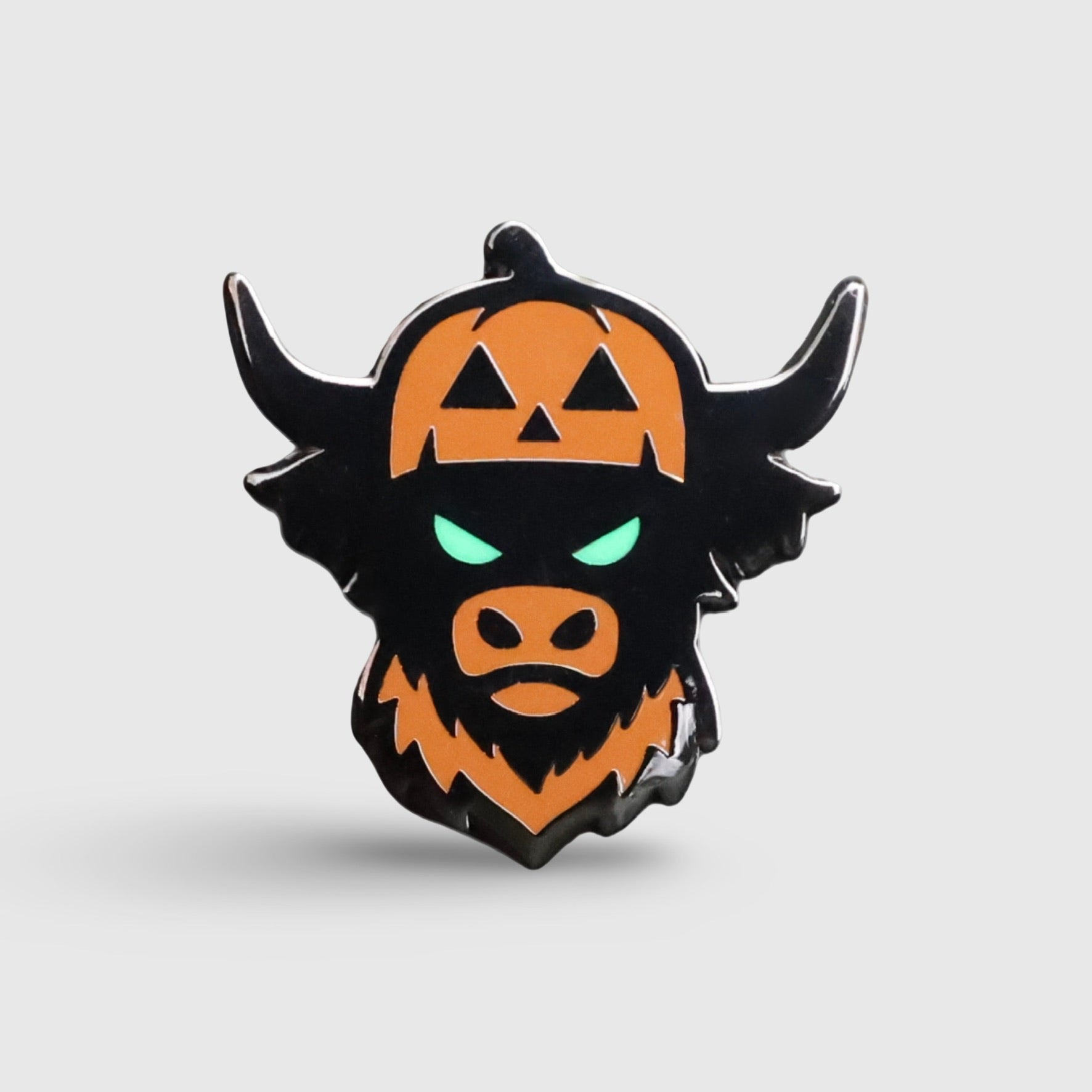 Caddy Collective Culture Looper After Dark Halloween ball marker featuring pumpkin Looper face with glow-in-the-dark green eyes on burnt orange background.