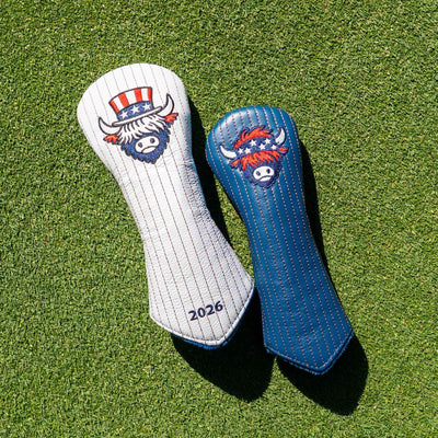 Two golf club headcovers placed on green grass. One cover is white with thin blue pinstripes and a buffalo logo with an American flag hat; the other is blue with matching pinstripes and the same buffalo logo.