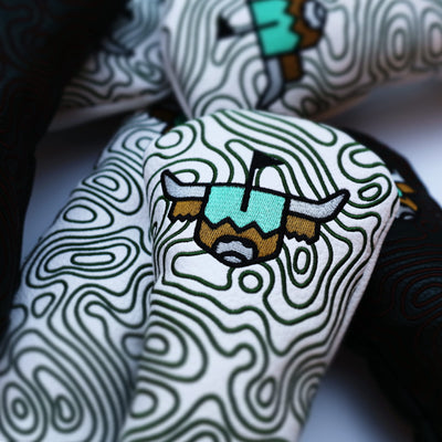 Close-up of embroidered Looper logo on white hybrid golf headcover