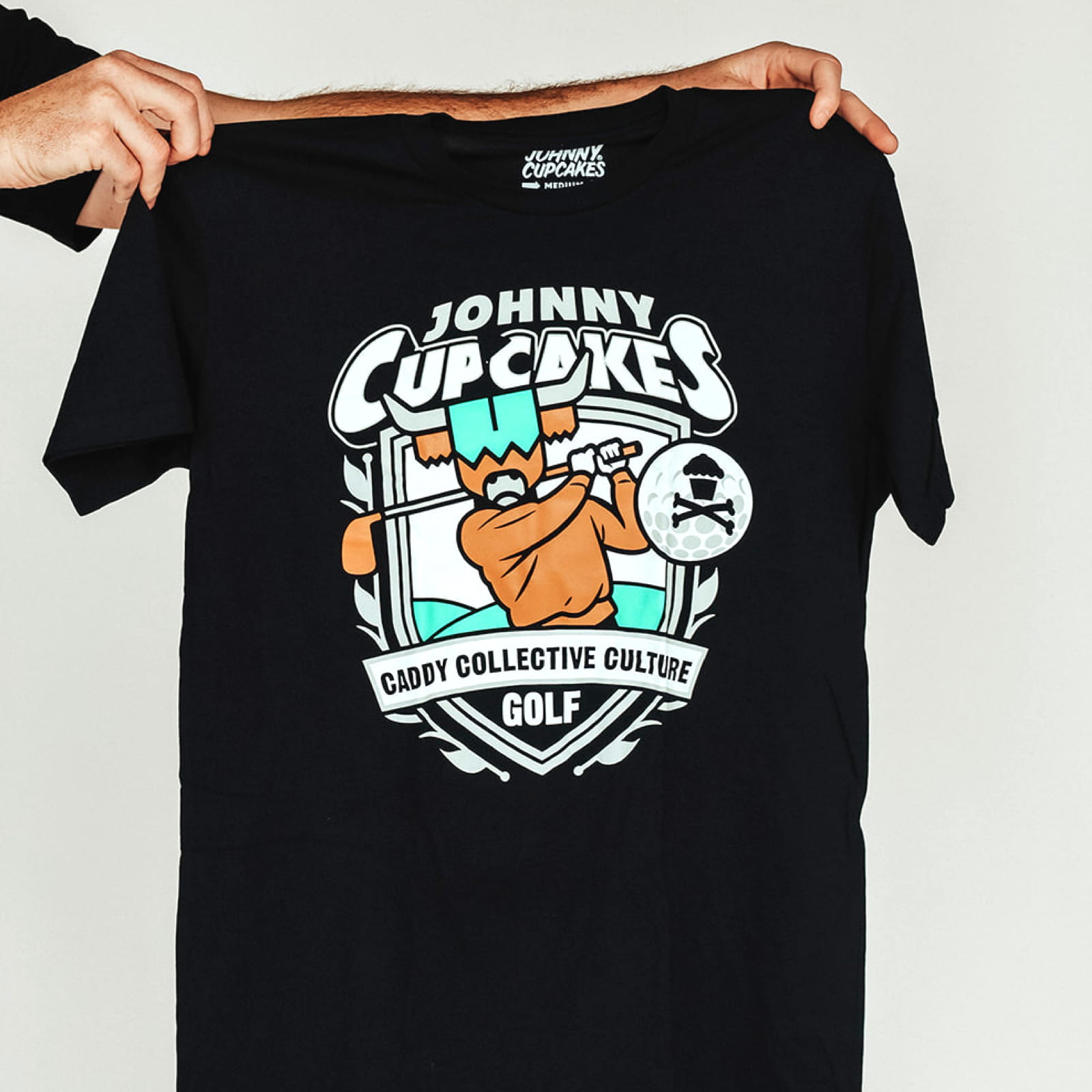 Johnny Cupcakes x CCC golf T-shirt displayed flat, front graphic visible
