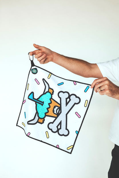 Golf towel with Johnny Cupcakes cupcake skull logo held by hand
