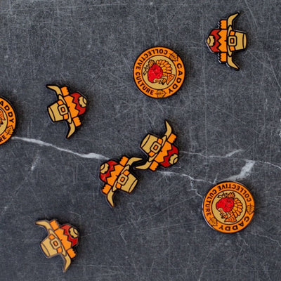 Multiple Pilgrim Looper and Harvest Turkey ball markers by Caddy Collective Culture displayed on a dark stone background.