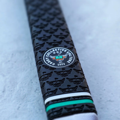 Close-up of CCC logo badge on Quad Tour putter grip with embossed Looper texture