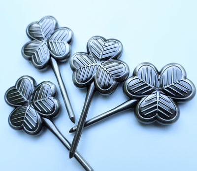 Collection of four clover-shaped golf divot tools photographed on light background