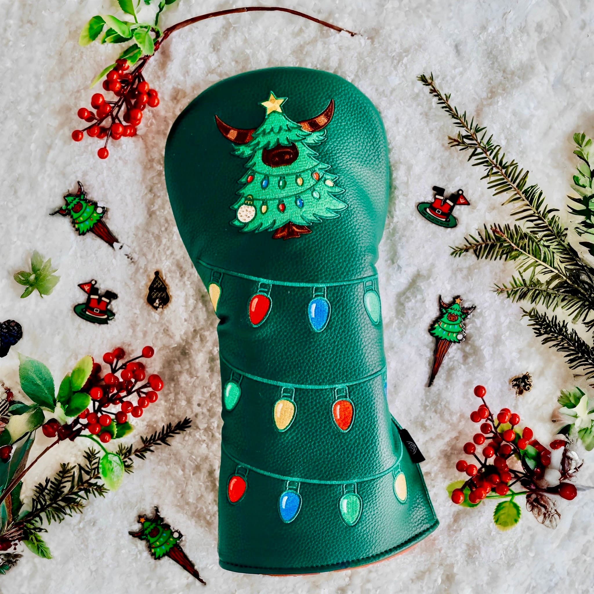 Flatlay of Evergreen Collection driver headcover surrounded by snow, greenery, berries, and matching accessories.