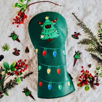 Flatlay of Evergreen Collection driver headcover surrounded by snow, greenery, berries, and matching accessories.