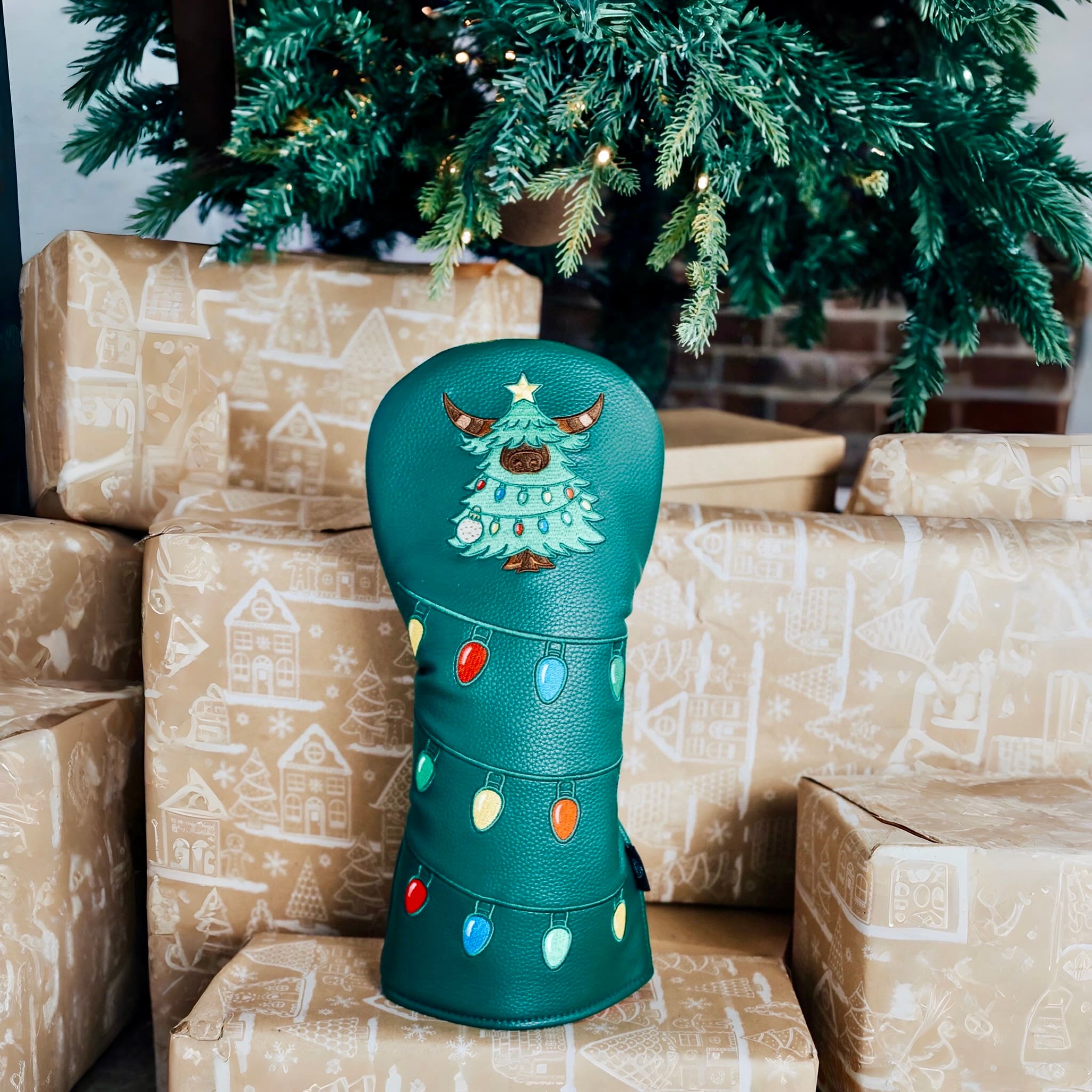 Evergreen driver headcover displayed indoors with a decorated Christmas tree in the background.