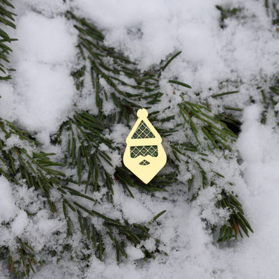 Centered view of the Santa Silhouette ball marker on snow-covered pine needles.