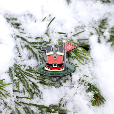 Santa’s Soft Landing ball marker placed in snow-covered pine branches, creating a winter golf aesthetic.