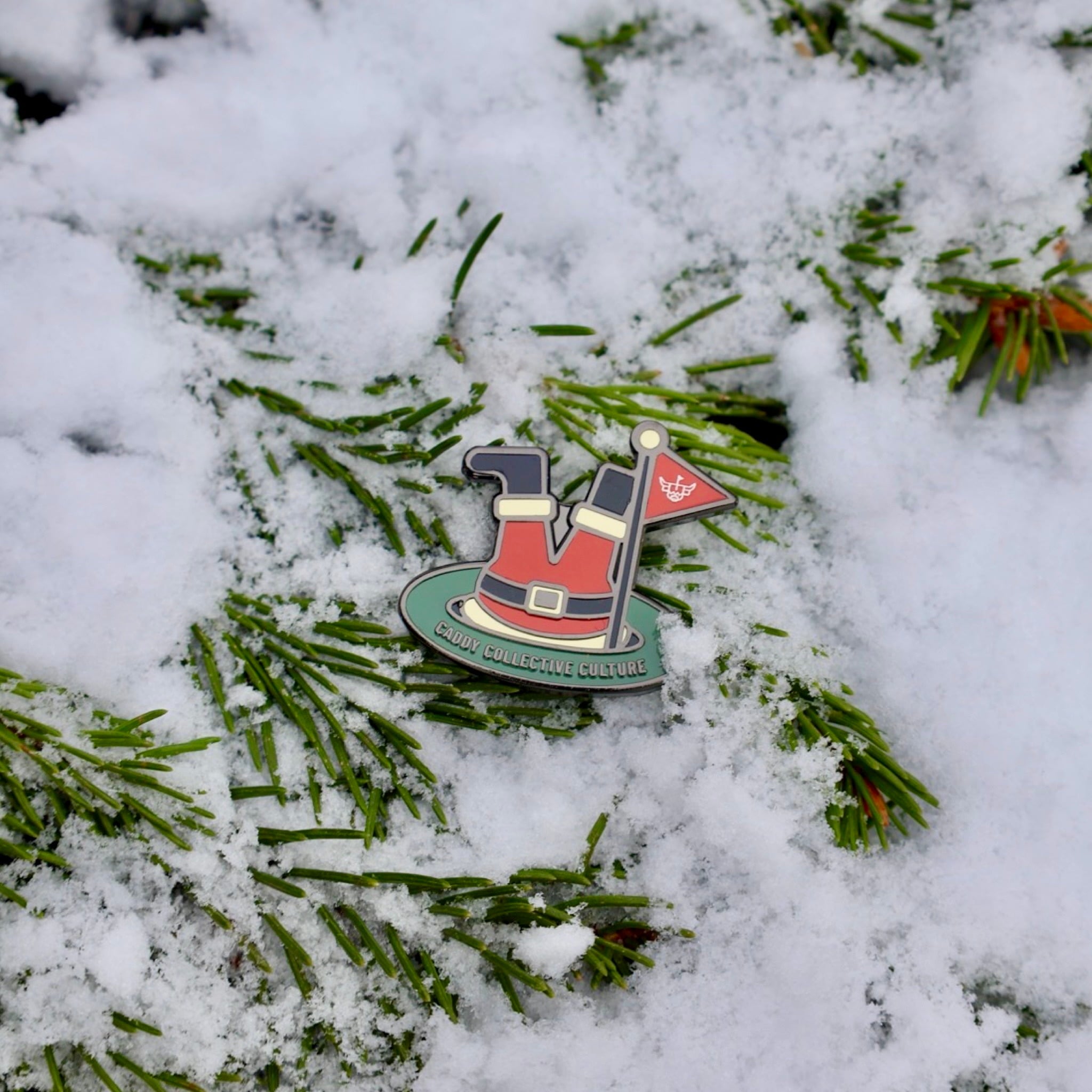 Santa’s Soft Landing ball marker resting in snowy holiday texture with vibrant red suit and green putting surface.