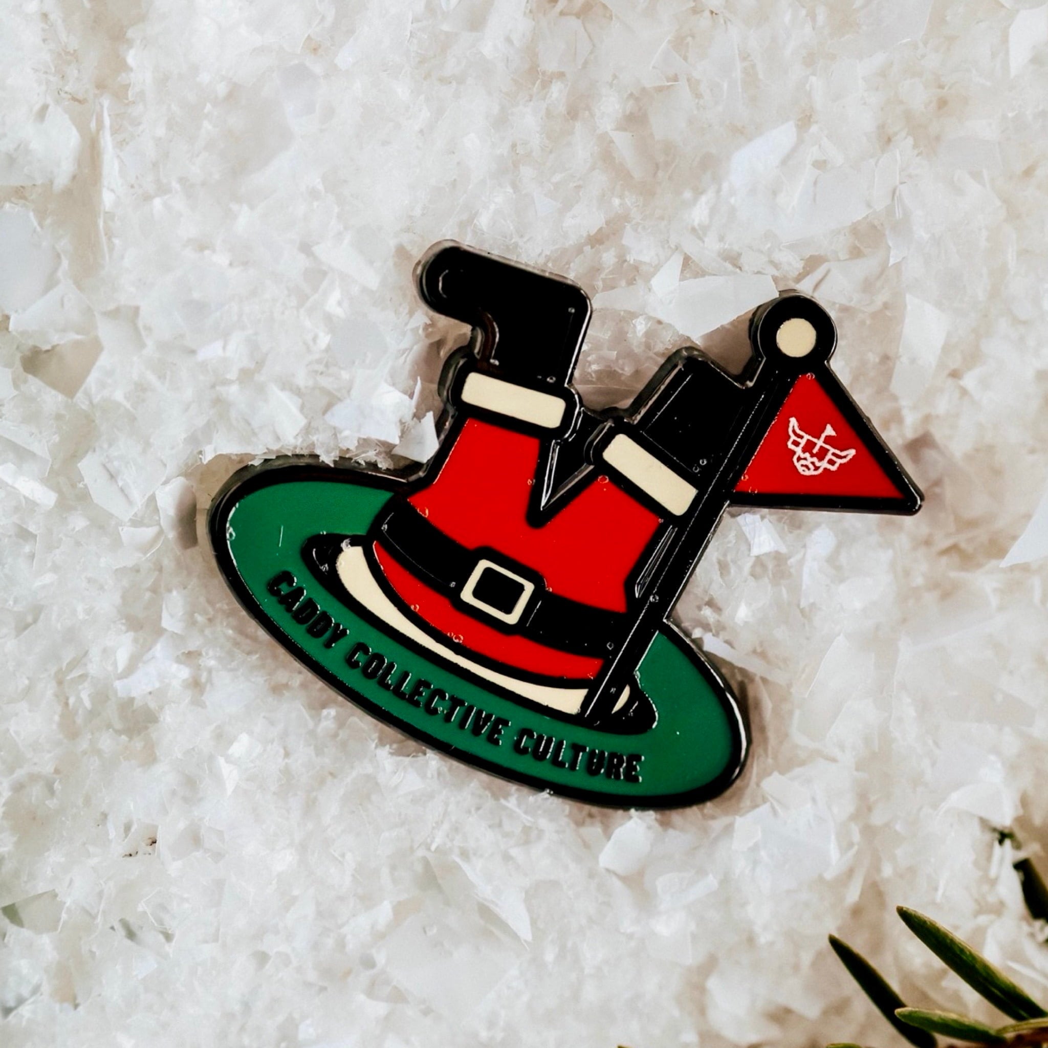 Close-up of the Santa’s Soft Landing golf ball marker on snow, highlighting enamel colors and festive design.
