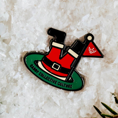 Close-up of the Santa’s Soft Landing golf ball marker on snow, highlighting enamel colors and festive design.