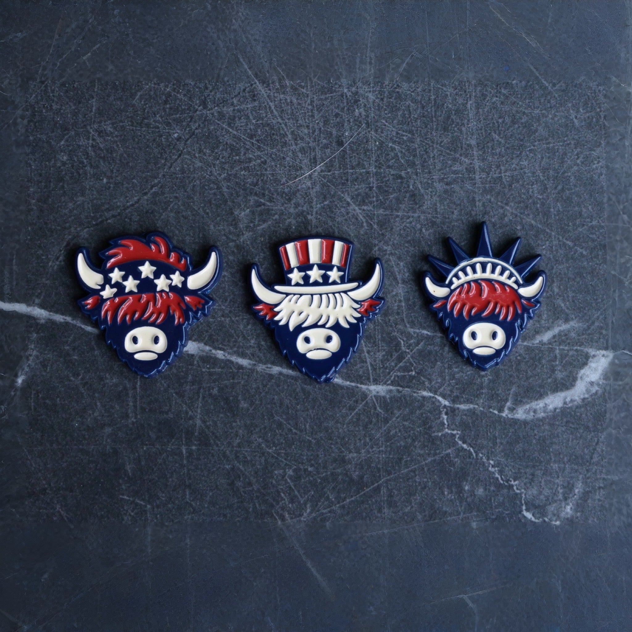 The Founders Collection golf ball markers featuring Patriot, Founder, and Liberty Looper designs displayed on dark marble background