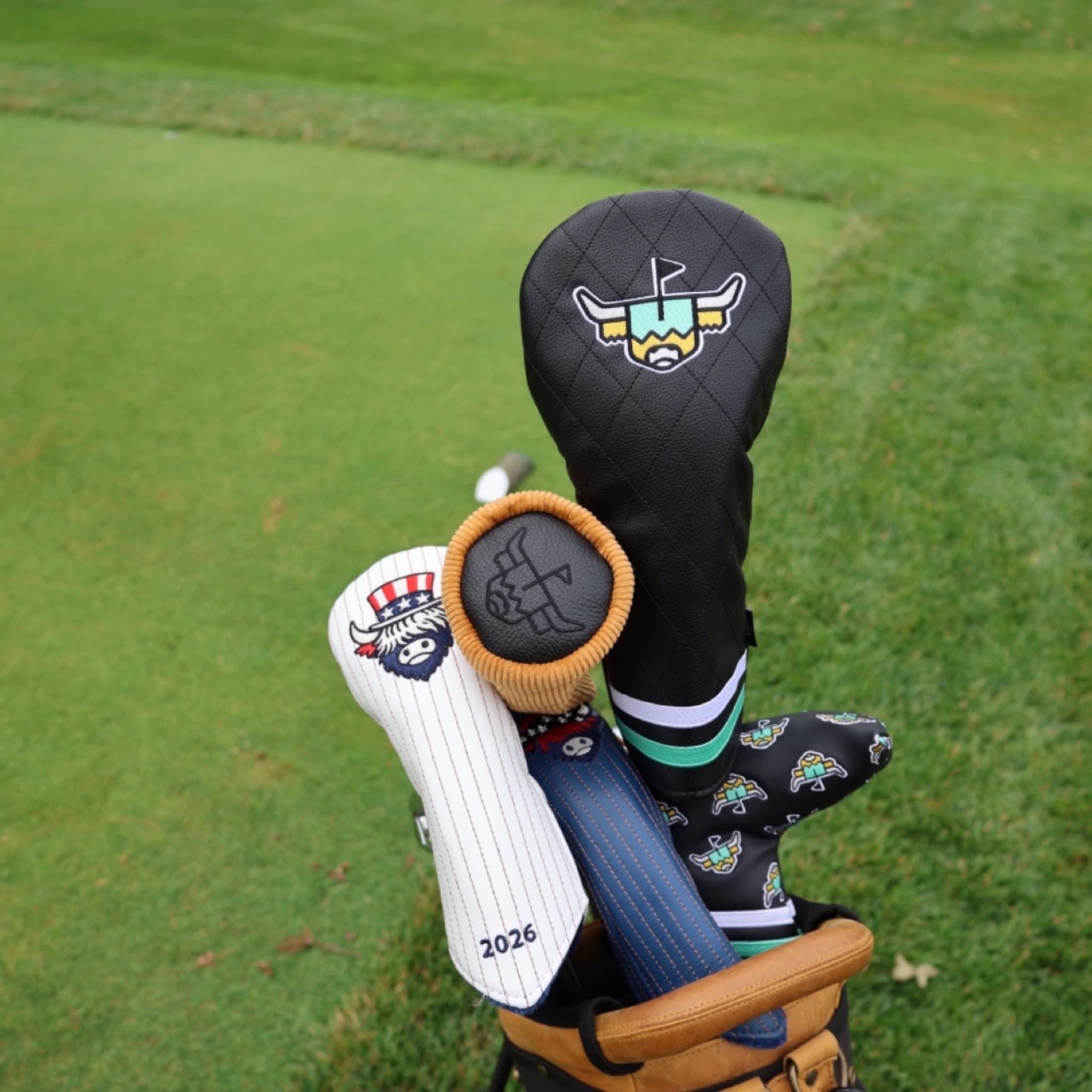 Premium patriotic golf headcovers from the Founders Collection displayed together in a golf bag on the golf course.