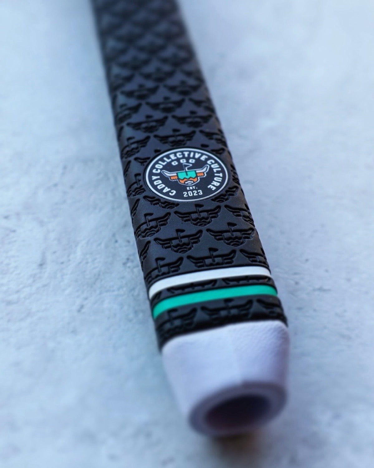 Custom Garsen golf putter grip collaboration featuring the Caddy Collective Culture logo and embossed grip pattern.