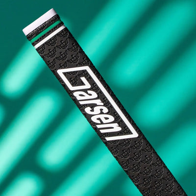Close-up of a black Garsen putter grip with a large white Garsen logo, embossed caddy pattern, green accent ring, and white end cap on a teal background.