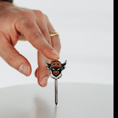 Looper After Dark combo tool held in hand showing black metal finish and pumpkin Looper design