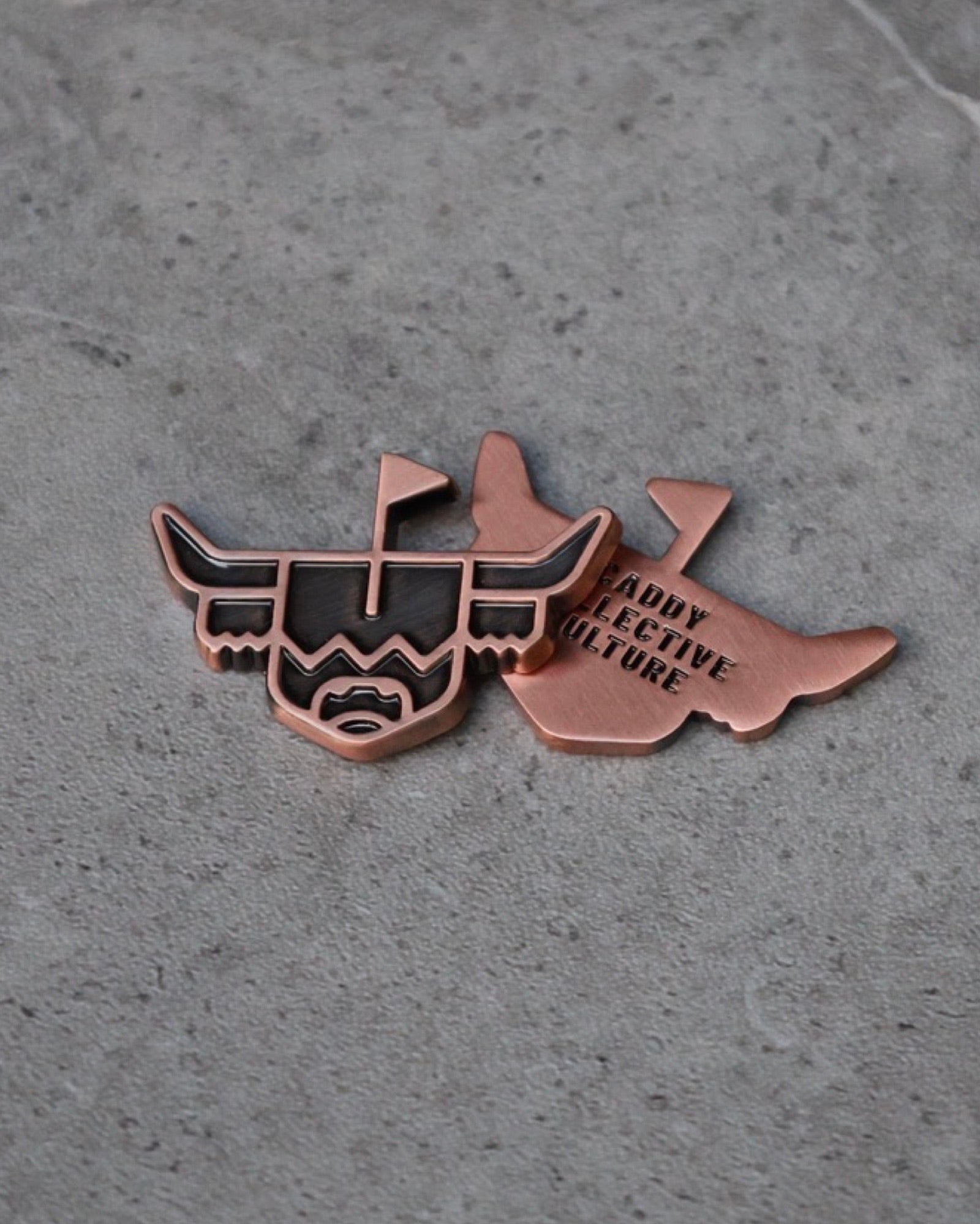 Front and back of the Looper Brass Ball Marker with hand-aged finish and Caddy Collective engraving