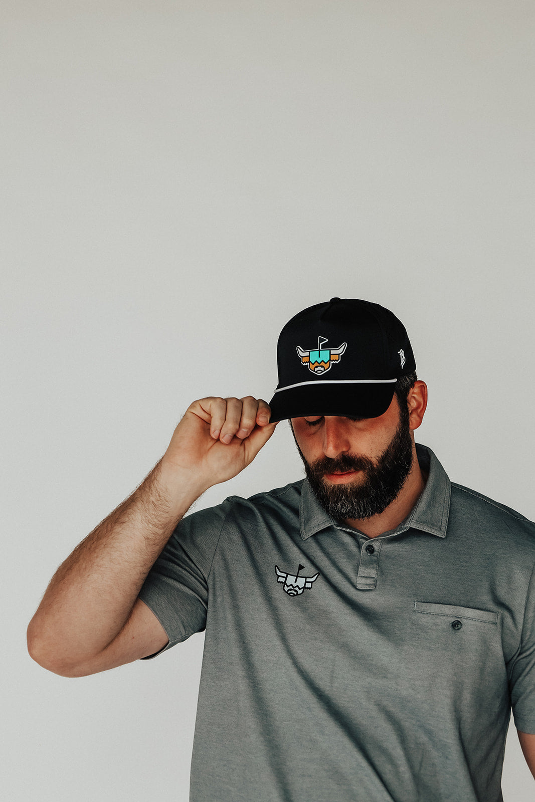 Model wearing the Looper Rope Hat, tipping the brim to highlight fit and front design.