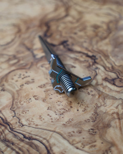Looper Threaded Divot Tool displayed on olive wood highlighting handcrafted stainless steel construction.