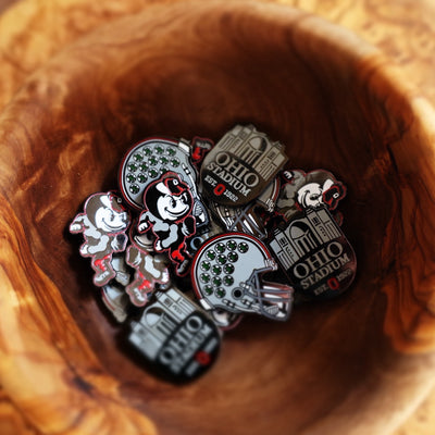 Ohio State Heritage Brutus Ball Marker featured inside carved wooden bowl with Buckeye Right Helmet and Horseshoe markers