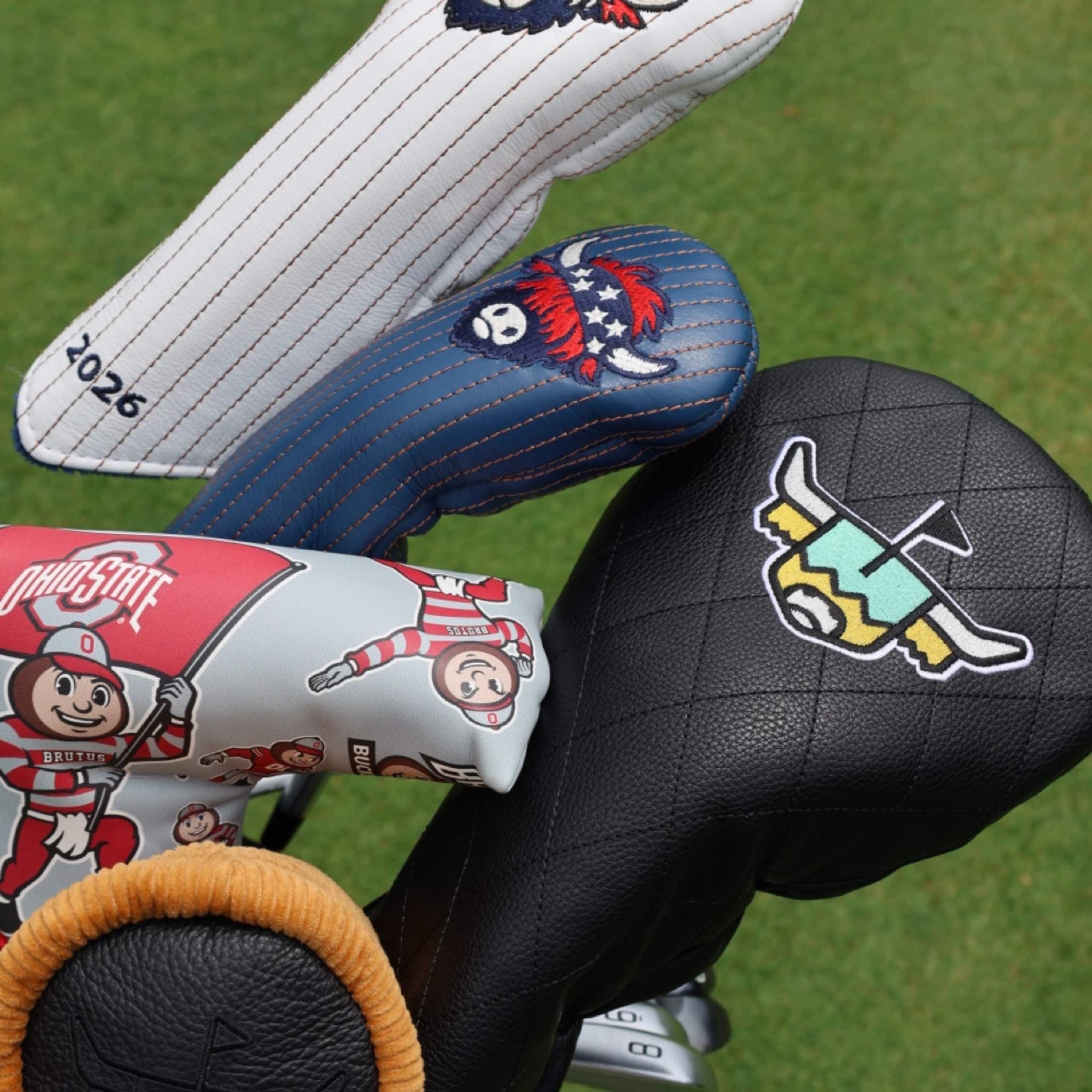 Luxury golf headcovers including Founders Collection, Quilted Heritage, and Ohio State designs displayed in a golf bag on the golf course.