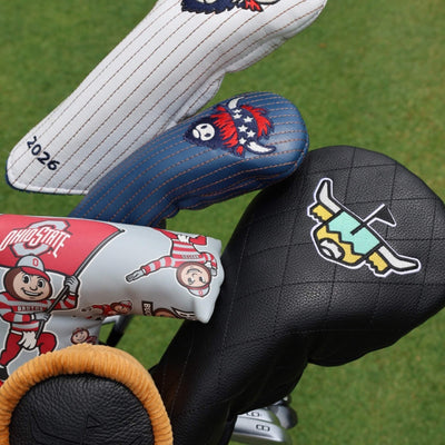 Luxury golf headcovers including Founders Collection, Quilted Heritage, and Ohio State designs displayed in a golf bag on the golf course.