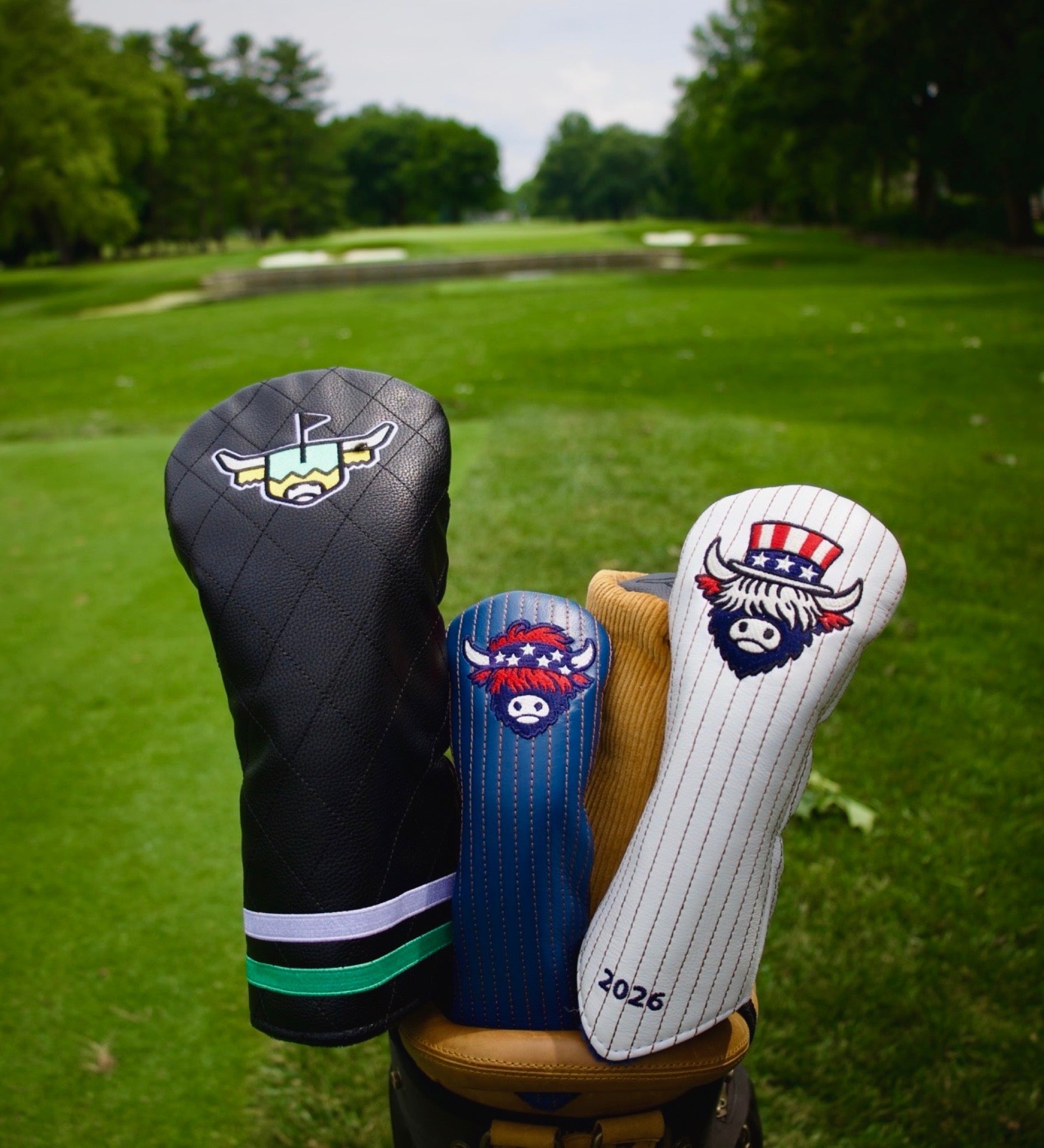 Premium leather golf headcovers from the Founders Collection and Quilted Heritage Collection displayed on a golf course fairway.