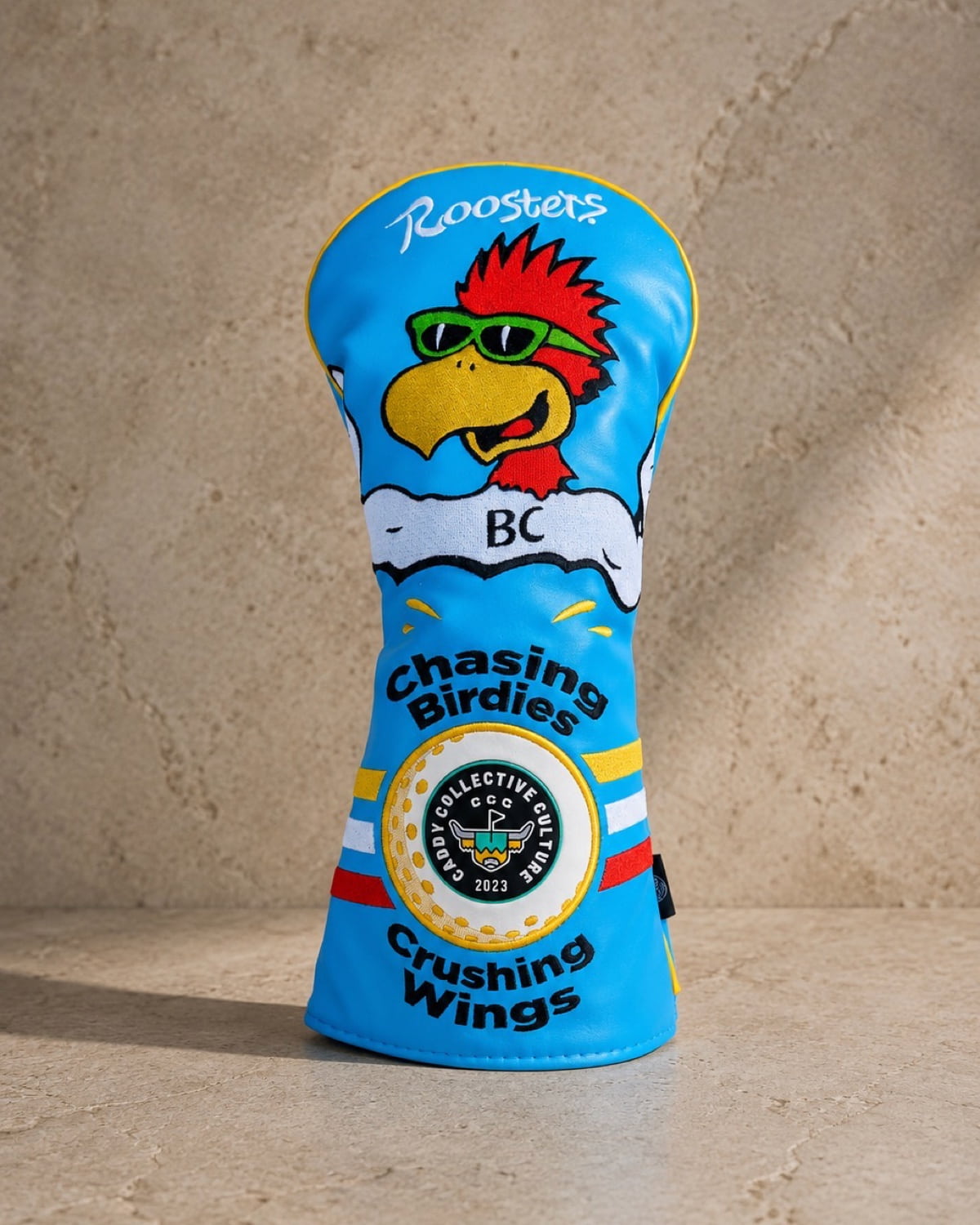 Luxury product photo of a custom Roosters Wings golf headcover collaboration created by Caddy Collective Culture.