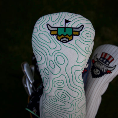 Terrain Driver Headcover on a golf bag showing the white pebbled grain leather and embroidered green contour pattern.