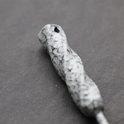 Close-up of Twisted Metal single prong divot tool in Palleon White finish highlighting organic forged texture